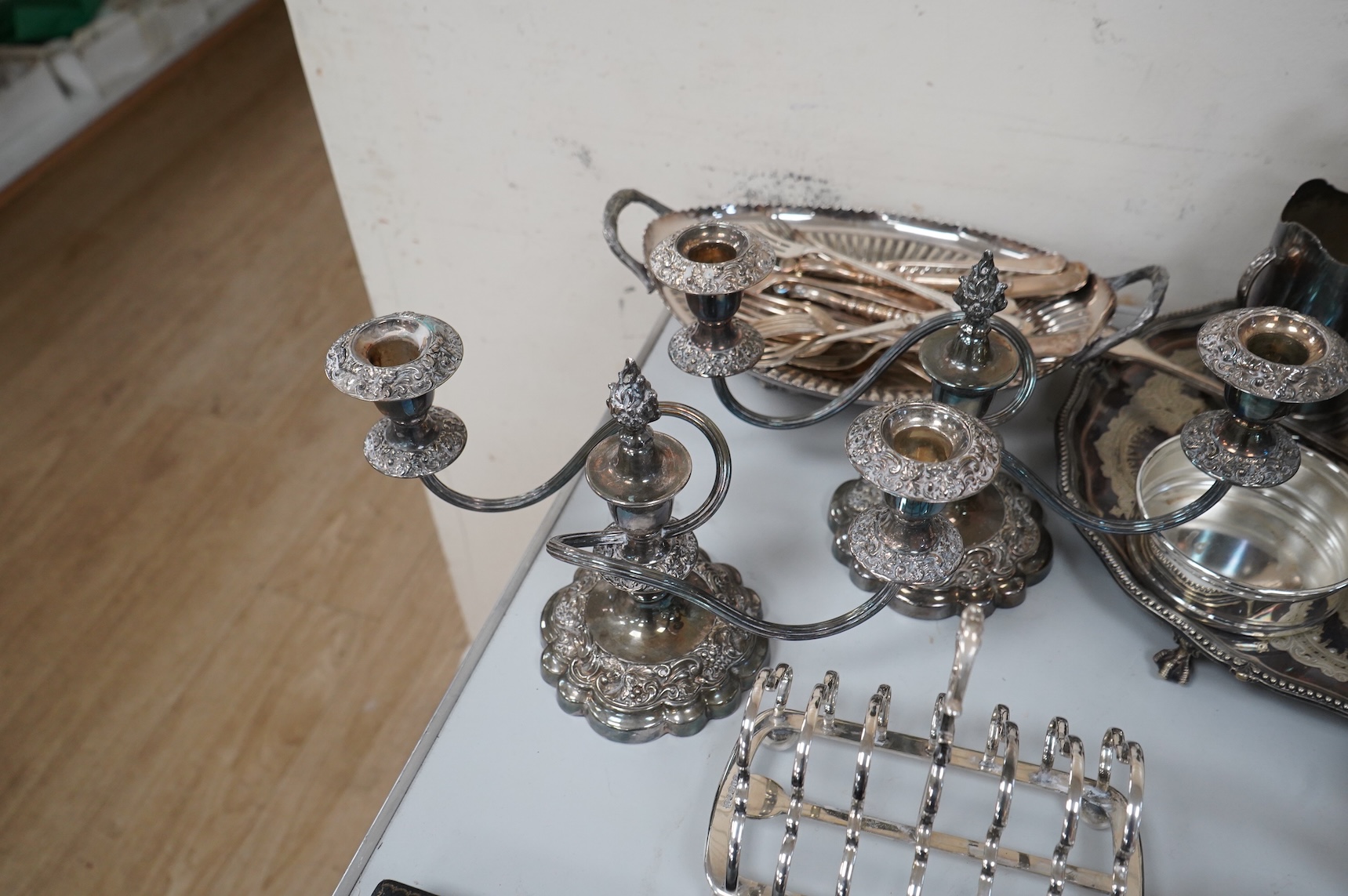 A collection of silver plate to include cased dessert forks, a hammered tea pot, pair of candlesticks and a salver